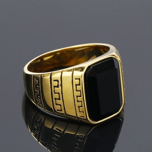 Makro-Seitenansicht des goldenen Herren-Siegelrings mit schwarzem Stein und griechischem Muster