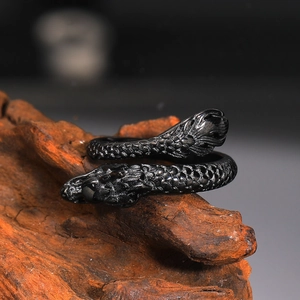 Detailed close-up of vintage black dragon scale ring on natural wood background