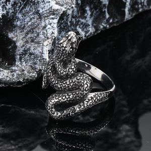 Vintage punk snake ring in silver titanium steel with detailed scales on rock background