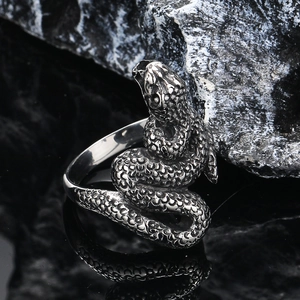 Vintage punk silver snake ring for men with realistic scale texture on dark stone background