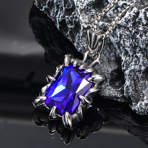 Macro detail of rectangle blue gemstone pendant with punk style claw setting and chain
