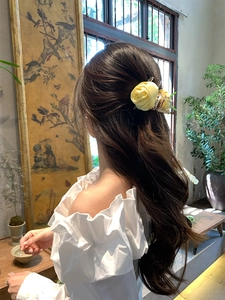 Fermaglio per capelli con rosa in seta giallo pallido indossato in una acconciatura