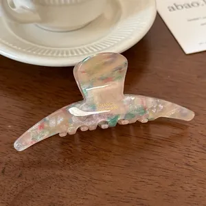 Handmade tortoise acetate hair claw clip with golden France engraving on wood desk