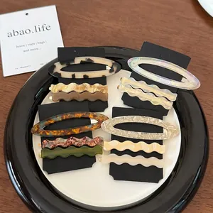 Set of oval wave acetate hair clips in tortoiseshell and marble patterns on display