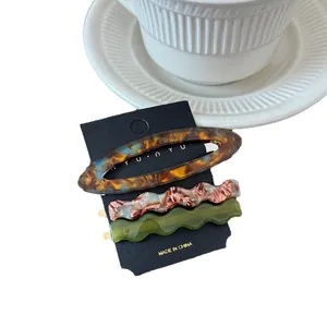3-pack oval wavy acetate hair clips with tortoiseshell and marble patterns on black card