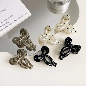Elegant polka dot bow hair claw clips in pearl white, grey, and black colors