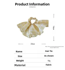 Detailed size parameters of the yellow and white checkered scrunchie showing 23cm width
