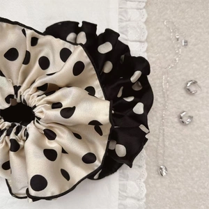 Close-up detail of oversized polka dot scrunchie fabric texture and delicate stitching