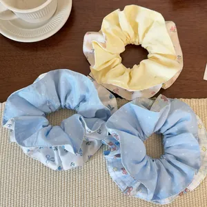 Detailansicht von Haargummis mit Blumenmuster und Bären auf einem gemütlichen Holztisch