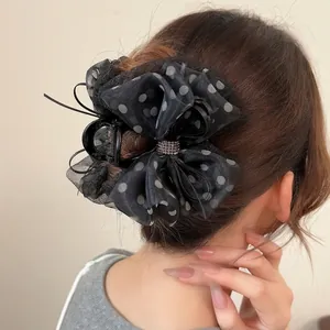 Pince à cheveux avec nœud en tulle à pois et strass, portée de profil par un modèle