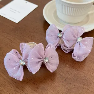 Detail of lavender mesh bow hair claw clips with rhinestones on a wooden table