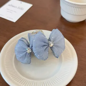 Close-up of blue mesh bow hair claw with sparkling crystal and wavy edges on a tray