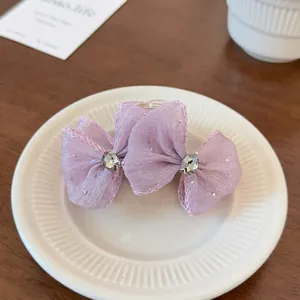 Detail of light purple mesh bow hair claw clip with sparkly rhinestones and elegant fabric
