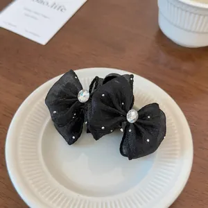 Detail of black mesh hair claw with sparkling rhinestones and elegant double bow design
