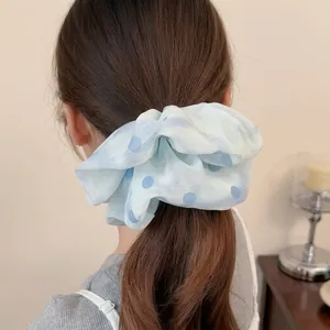 Elastico per capelli in rete a pois blu mostrato in una coda di cavallo su una modella