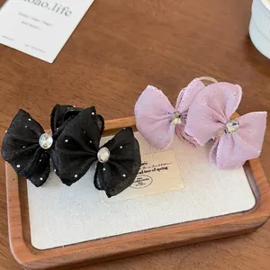 Summer rhinestone mesh bow hair claw clips in black and lavender on a wooden tray