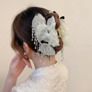 Detail of elegant organza bow hair claw clip with sparkling rhinestone fringe tassels
