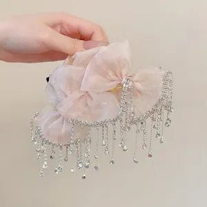 Detail of light pink organza bow hair claw with sparkling rhinestone tassels for women