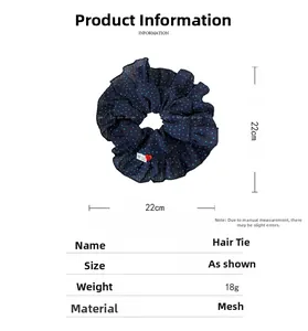 Détail d'un chouchou en tulle à pois bleu marine avec étiquette faite main et diam 22cm