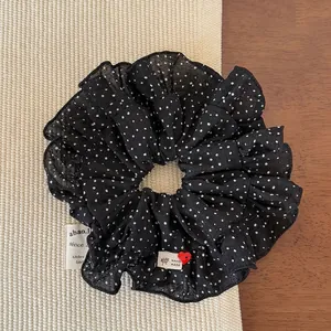 Détail d'un chouchou à pois avec étiquette faite main et décor de bouton cœur rouge