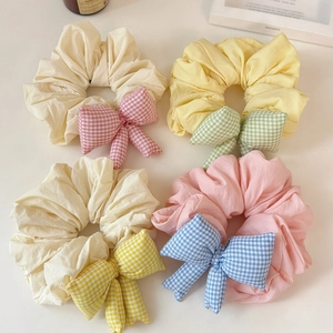 Set of four pastel plaid bow scrunchies in cream, yellow, apricot and pink shades