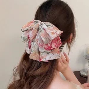 Barrette à cheveux nœud en mousseline florale avec glands métalliques portés