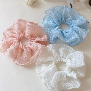 Gros plan de chouchous en seersucker rose bleu et blanc avec texture à carreaux
