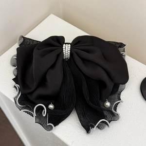 Detail of elegant black mesh bow hair claw clip with pleated mesh and pearls