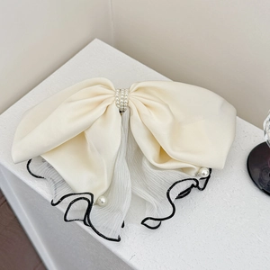 Detail of cream satin bow hair claw clip with white pearls and pleated mesh edges