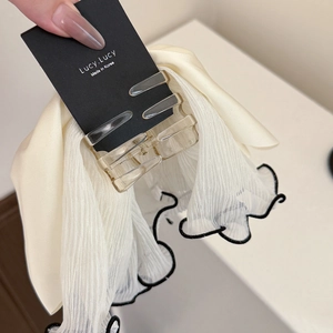 Close-up of cream chiffon mesh hair claw clip with black stitched edges and amber base