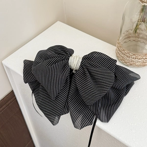 Detail of elegant black and white striped hair claw with delicate pearl centerpiece