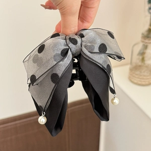 Detail view of the layered grey polka dot mesh bow hair clip with white pearl pendants