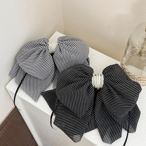 Detailed view of striped bow headbands featuring elegant pearl bead center embellishments