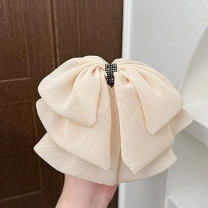 Macro detail of the oversized layered mesh bow hair claw with elegant black rhinestones