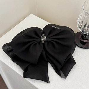 Close-up of elegant black mesh bow hair claw clip with sparkly silver rhinestones