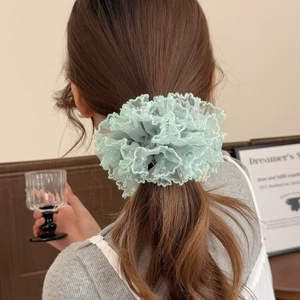 Detailaufnahme des hellgrünen Spitzen-Scrunchies mit Punkten an einem Zopf
