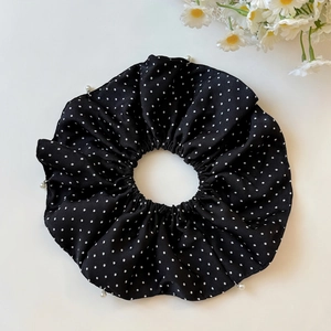 Detail shot of black polka dot chiffon hair scrunchie with elegant pearl embellishments