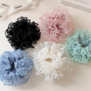 Detailaufnahme von 5-teiligen Falten-Spitzen-Scrunchies in Pastellfarben auf Elfenbein