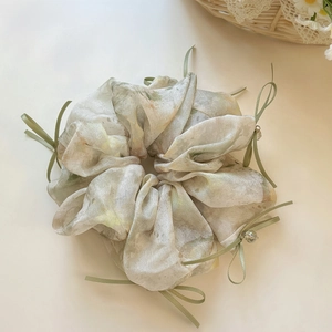 Detail of floral organza scrunchie with green ribbons and crystal heart pendants