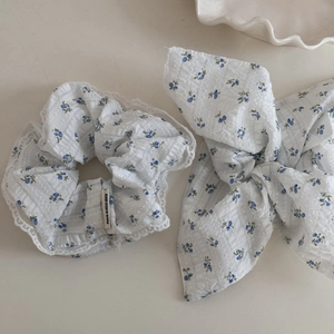 Detail of white floral scrunchie set with blue prints and delicate lace trim edges