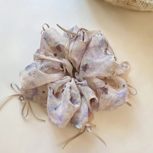 Close-up of fluffy floral organza scrunchie with pink ribbon bows and bead details