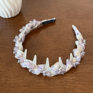 Close-up of handmade purple floral headband with crystal beads and wavy fabric texture