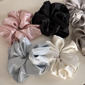 Detailed view of assorted satin silk scrunchies with elegant glossy texture and soft folds