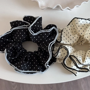Close-up of black and white polka dot chiffon scrunchies with contrast edging details