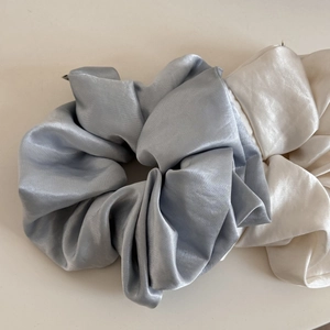 Detail of silver blue and cream white satin scrunchies with elegant glossy texture