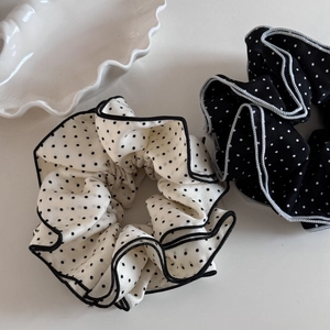 Detail of two-piece polka dot scrunchies with pleated fabric and contrast piping edges