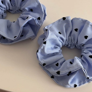 Détails des chouchous à rayures bleues avec motifs de cœurs noirs et texture du tissu