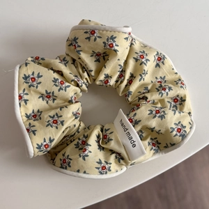 Vue détaillée du chouchou floral jaune avec étiquette fait main et liseré blanc