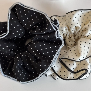 Close-up of black and white polka dot chiffon scrunchies with elegant ruffled edges