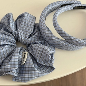 Détail d'un chouchou à carreaux bleu clair et de bandeaux assortis pour cheveux